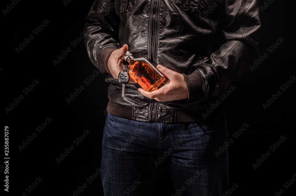 Anonymous alcoholic holding bottle of alcohol and car key. Don't Drink for Drive Anonymous alcoholic holding bottle of alcohol and car key. Don't Drink for Drive