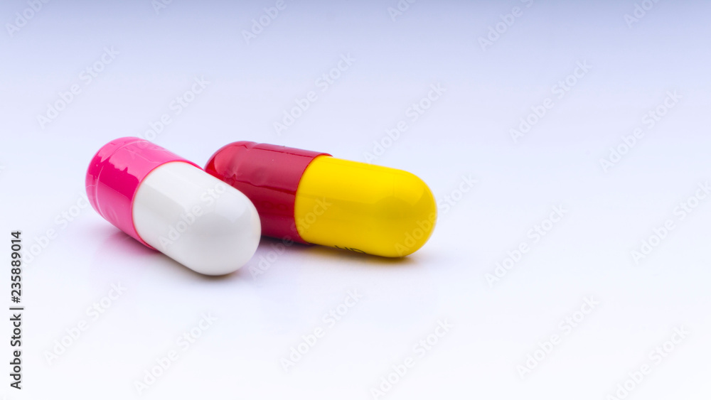Medicine pills or capsules closeup on a white background with selective focus and crop fragment Medicine pills or capsules closeup on a white background with selective focus and crop fragment
