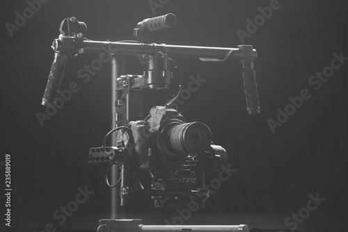 System stabilization video camera and lens on steady equipment support such as gimbal steady or stabilized. Black background