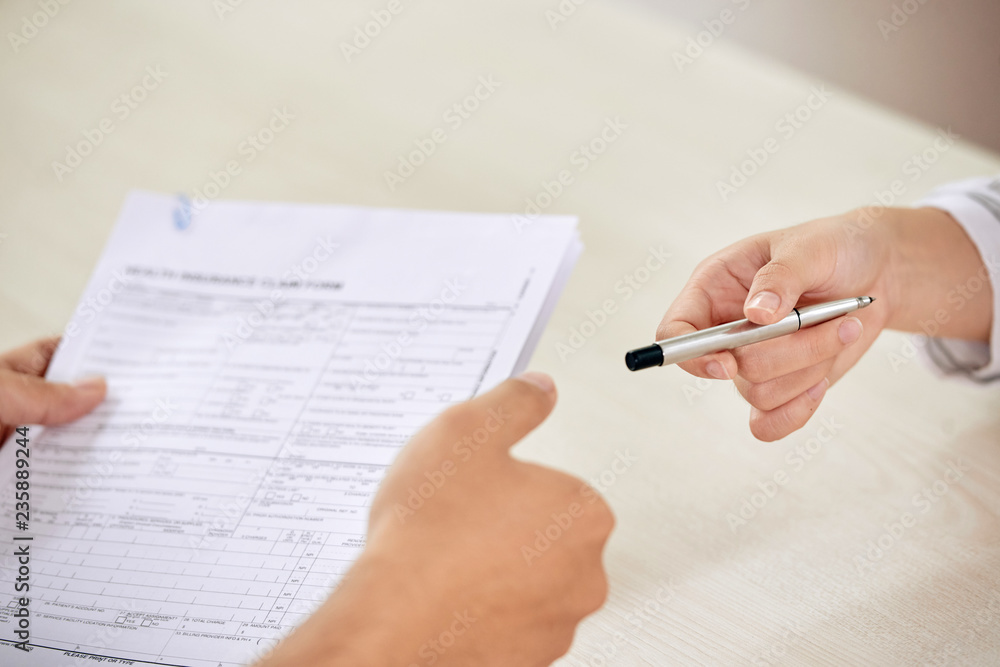 Crop person giving pen to colleague for signing paper contract on business meeting Crop person giving pen to colleague for signing paper contract on business meeting
