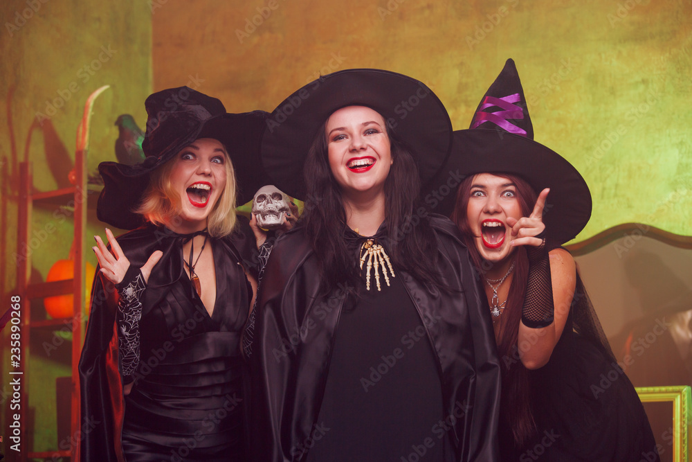 Obraz premium Photo of screaming three young witches in black hats