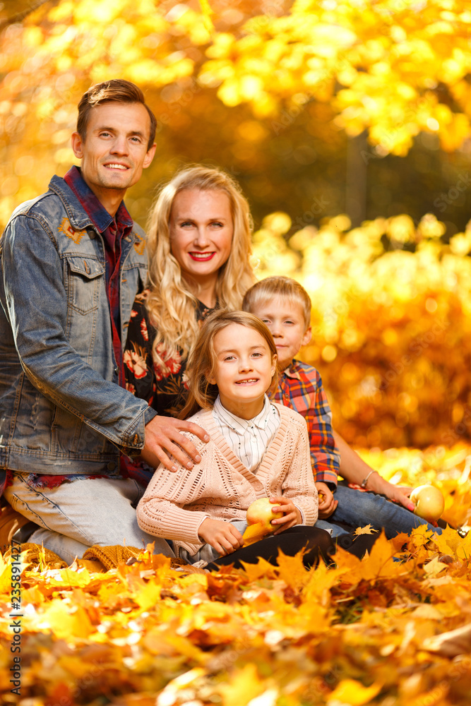Portait of cheerful parents and children sitting in autumn park Portait of cheerful parents and children sitting in autumn park