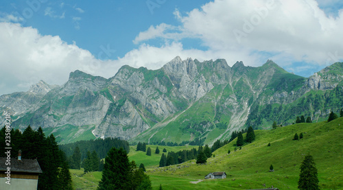 Das Alpsteinmassiv/ Bergwelt in der Schweiz; Blick auf das Alpsteinmassiv, steile Felsen, Bergwiesen, blauer Himmel und weiße Wolken