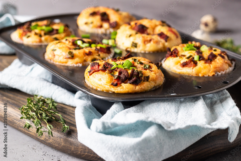 Savory muffins with bacon, quail egg, green onion cheese on a grey stone backdrop. Protein breakfast. Rustic style. Savory muffins with bacon, quail egg, green onion cheese on a grey stone backdrop. Protein breakfast. Rustic style.