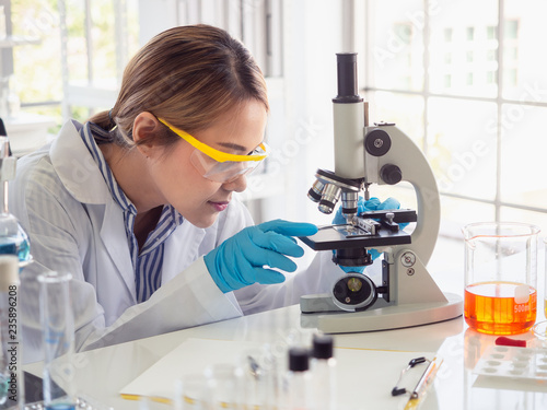 asian scientist working in laboratory with microscope