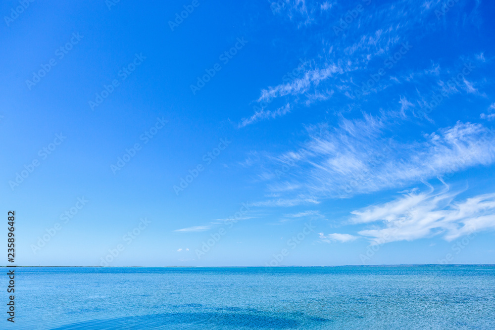 Obraz premium Beautiful blue sea water & vibrant sky with fluffy white clouds in summer.Beauty of nature for background design