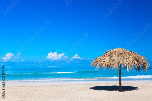 Straw umbrella on empty seaside beach in Varadero  Cuba. Relaxation  vacation idyllic background.