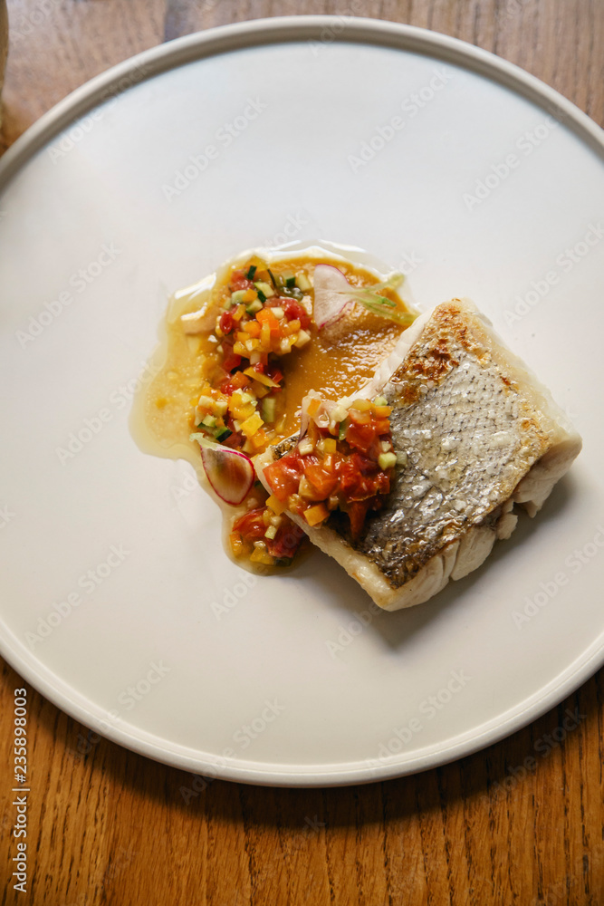 Hake fish served with vegetables on a white plate Hake fish served with vegetables on a white plate