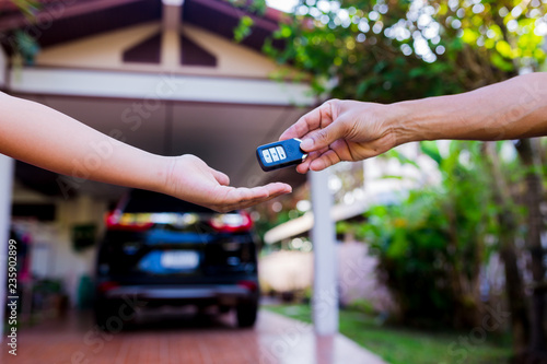 Fotografija Male hand holding a remote car key and handing it over to give another person