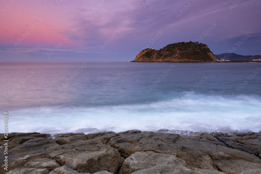 The waves breaking on the rocks at nightfall, with Getaria in the background, Basque Country