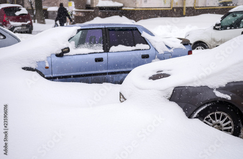 A snowstorm in the city. Cars on the streets in snowdrifts.