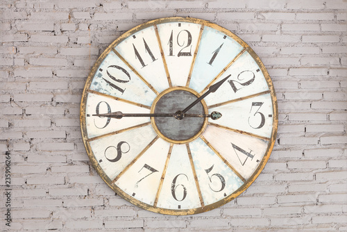 Retro clock showing one forty five on the wall