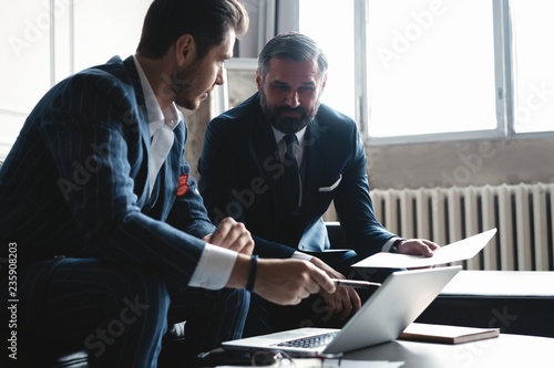 Business executives discussing work, developing strategy for online business, explaining sharing ideas, preparing presentation, having brainstorming session at office photo