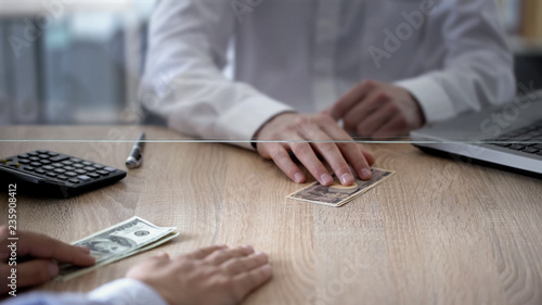 Exchange service worker giving japanese yens to client, changing for dollars photo