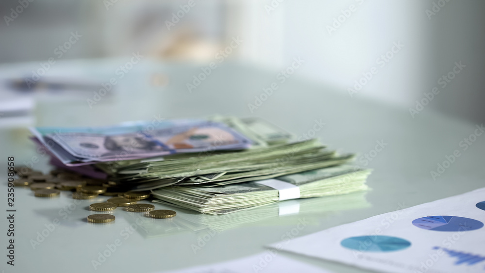 Stacks of dollar banknotes and coins on table, deposit, salary earnings, cash Stacks of dollar banknotes and coins on table, deposit, salary earnings, cash