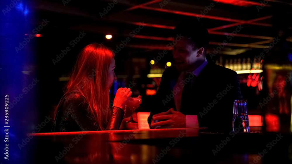 Confident business man talking to lady in nightclub, acquaintance, personal life