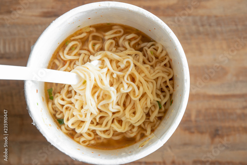 noodle soup in a cup view from top, instant noodles on wood background