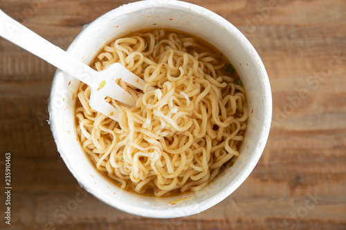 noodle soup in a cup view from top, instant noodles on wood background