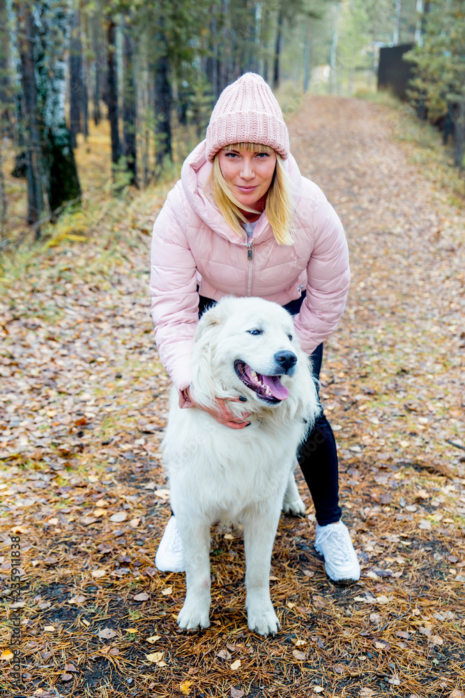 A pretty woman is walking her dog A pretty woman is walking her dog