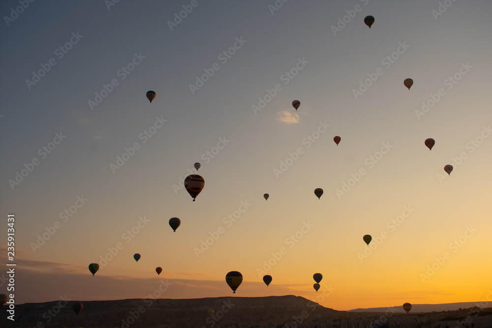 Beautiful sunset over Cappadocia, Goreme. Balloons flying against sky, aerial view. Most popular place in Turkey