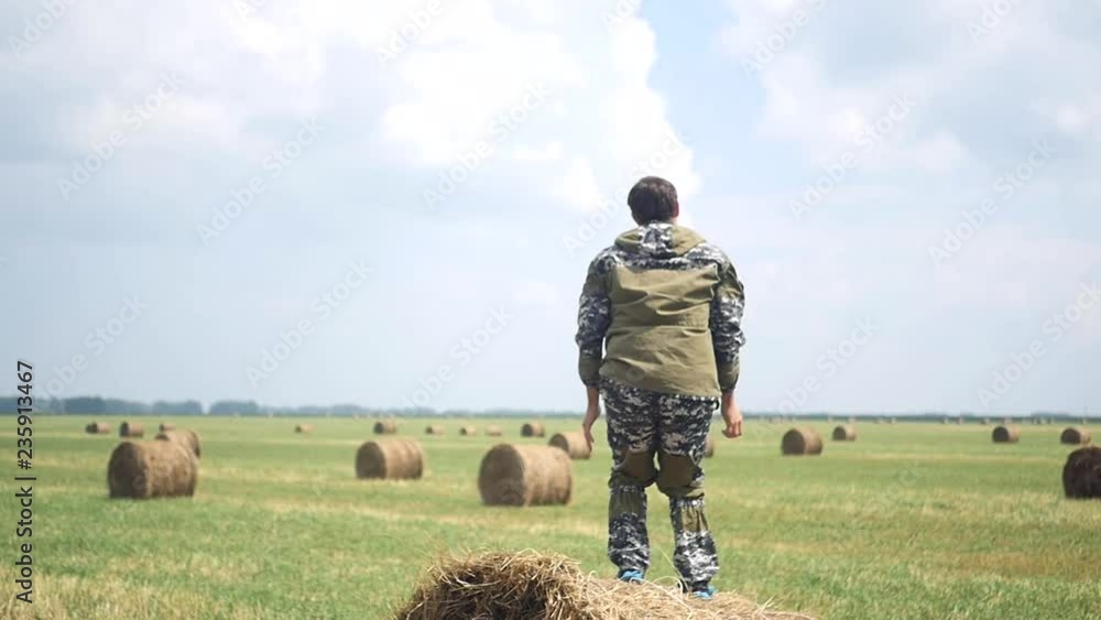 An adult man stands on a haystack and jumps for joy. slow motion, 1920x1080, full hd An adult man stands on a haystack and jumps for joy. slow motion, 1920x1080, full hd