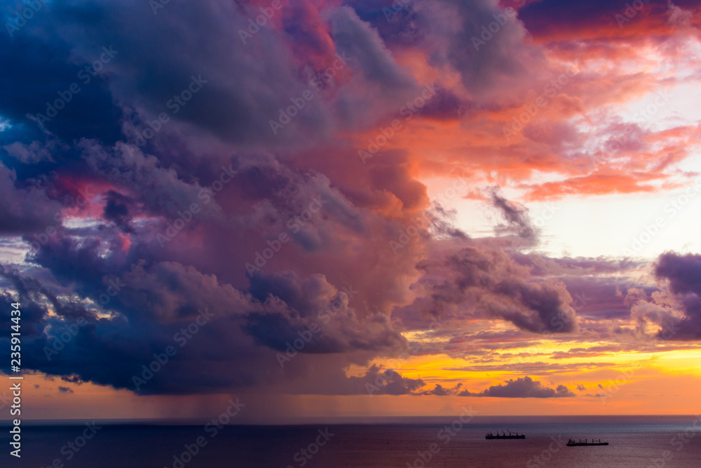 Obraz premium Magnificent colored clouds on the sea at sunset in the evening