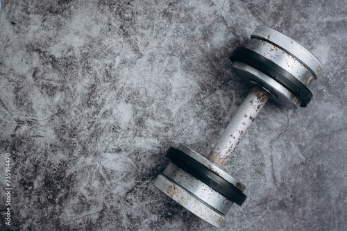 Fitness or bodybuilding concept background. Old iron dumbbells on grey, conrete floor in the gym. Top view. Healthz lifestyle.