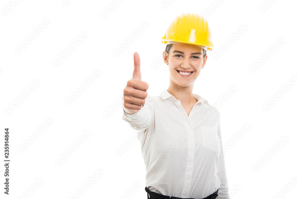 Young pretty business woman showing like gesture wearing helmet Young pretty business woman showing like gesture wearing helmet