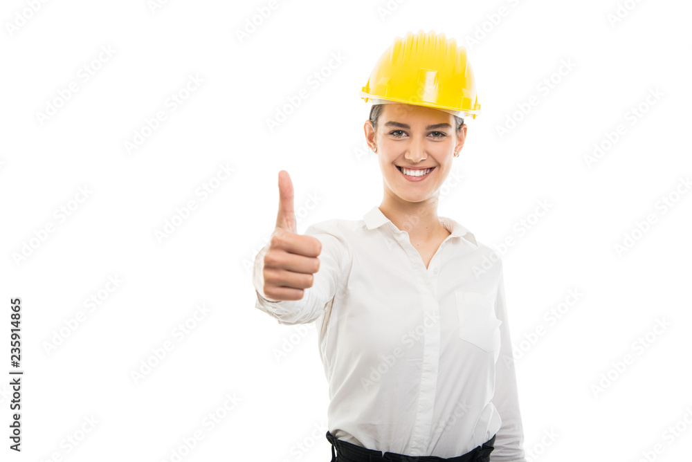 Young pretty business woman showing thumb up gesture wearing helmet Young pretty business woman showing thumb up gesture wearing helmet