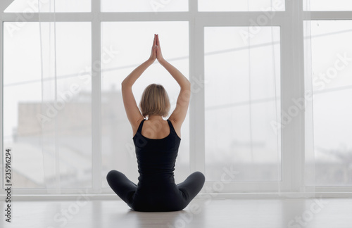 Woman practicing yoga looking out the window