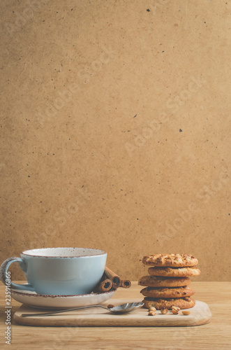 cinnamon sticks, cookies and a cup of coffee/cinnamon sticks, cookies and a cup of coffee on a wooden background with copy space