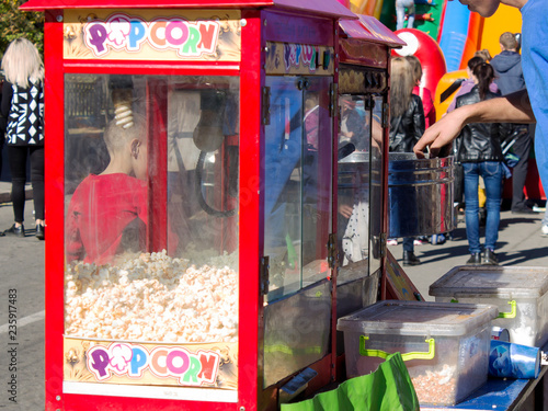 A young man sells popcorn and cotton candy in the square.