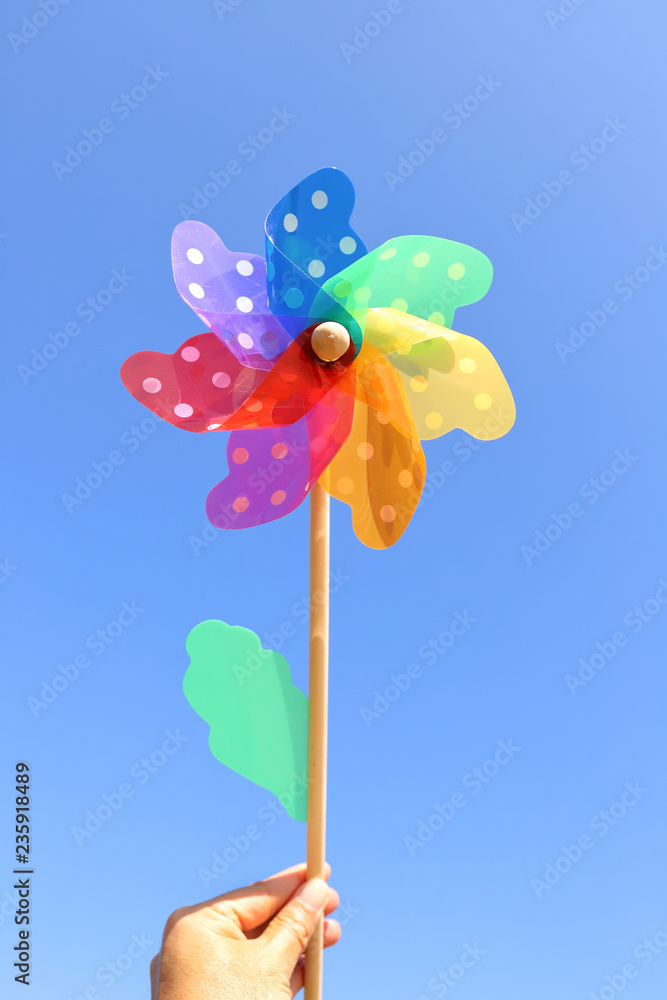 Wind turbine play on hand with blue sky background. Wind turbine play on hand with blue sky background.