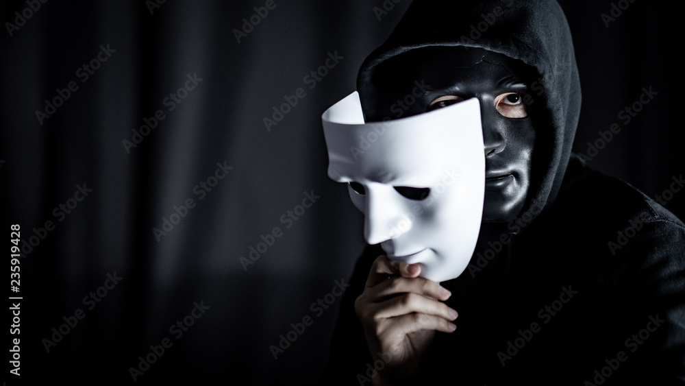 Mystery hoody man wearing black mask holding white mask. Anonymous social  masking. Major depressive disorder or bipolar disorder. Halloween concept  Stock Photo | Adobe Stock