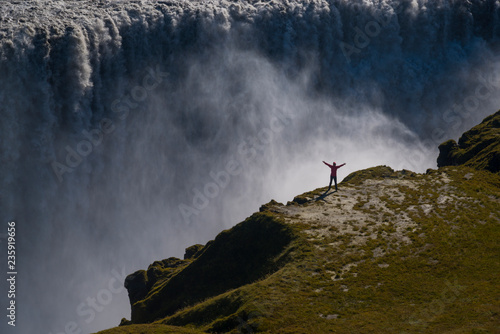 Happy tourist against Dettifoss waterfall background photo