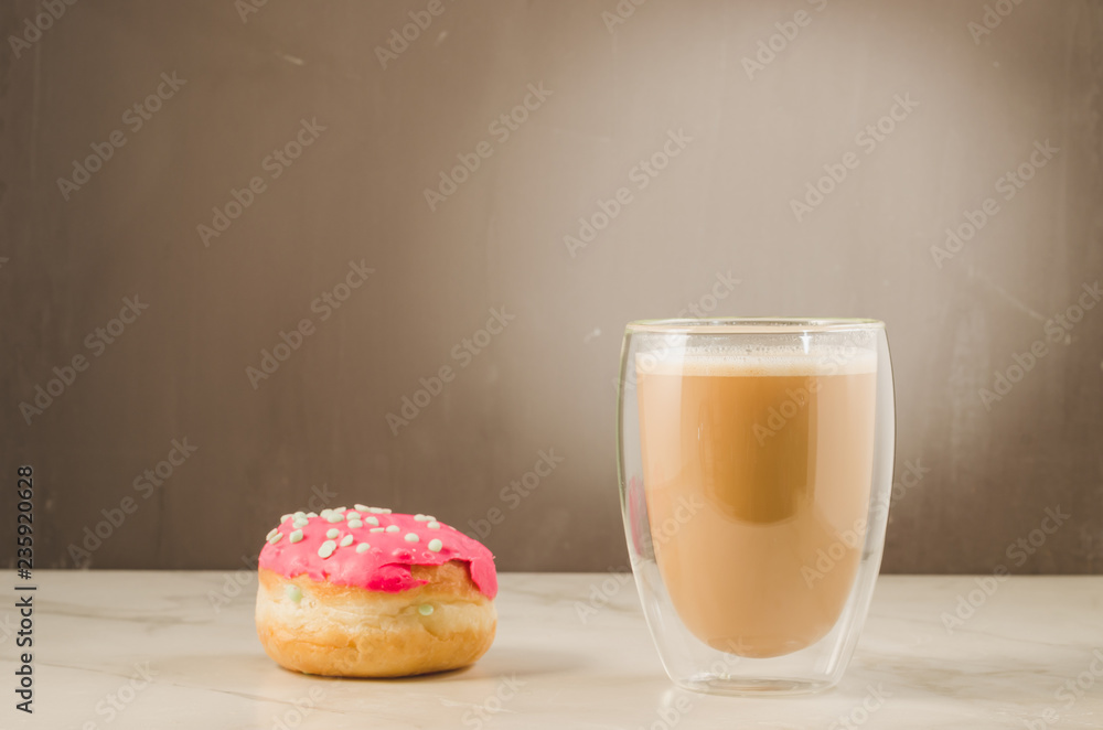 donut in red glaze and a cappuccino/donut in red glaze and cappuccino on a dark background with copy space
