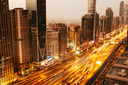 Beautiful aerial view to Dubai downtown city center lights skyline in the twilight, United Arab Emirates. Long exposure light trails effect