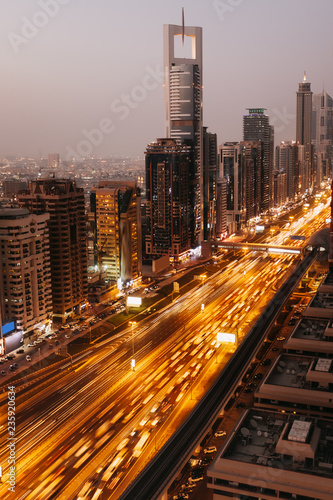 Beautiful aerial view to Dubai downtown city center lights skyline in the twilight, United Arab Emirates. Long exposure light trails effect