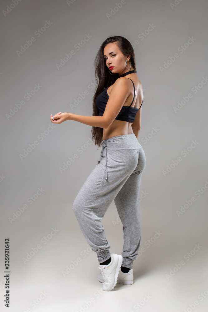 Modern dancer poses in front of the gray studio background Modern dancer poses in front of the gray studio background