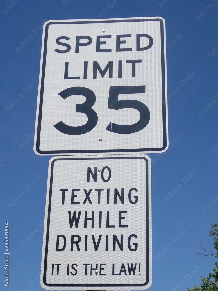 A road sign showing a speed limit and also an instruction stating no texting while driving                              