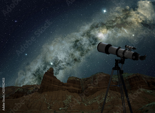 telescope on tripod looking at the milky way in night sky