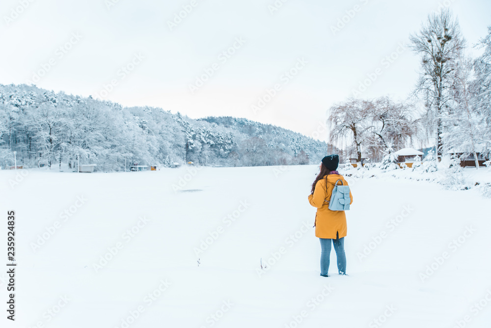 woman standing at frozen lake with beautiful landscape view copy space