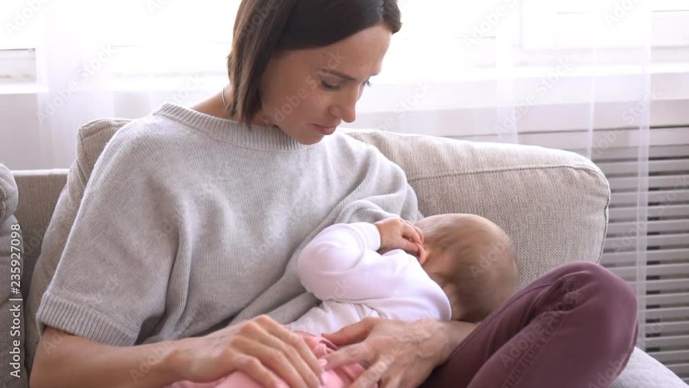 Mother breastfeeding baby daughter at home Mother breastfeeding baby daughter at home