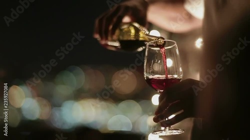 Waiter pours wine into a glass 