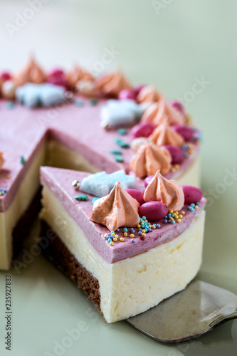 homemade cake decorated with edible Christmas trees and sweets on a bright mirror background