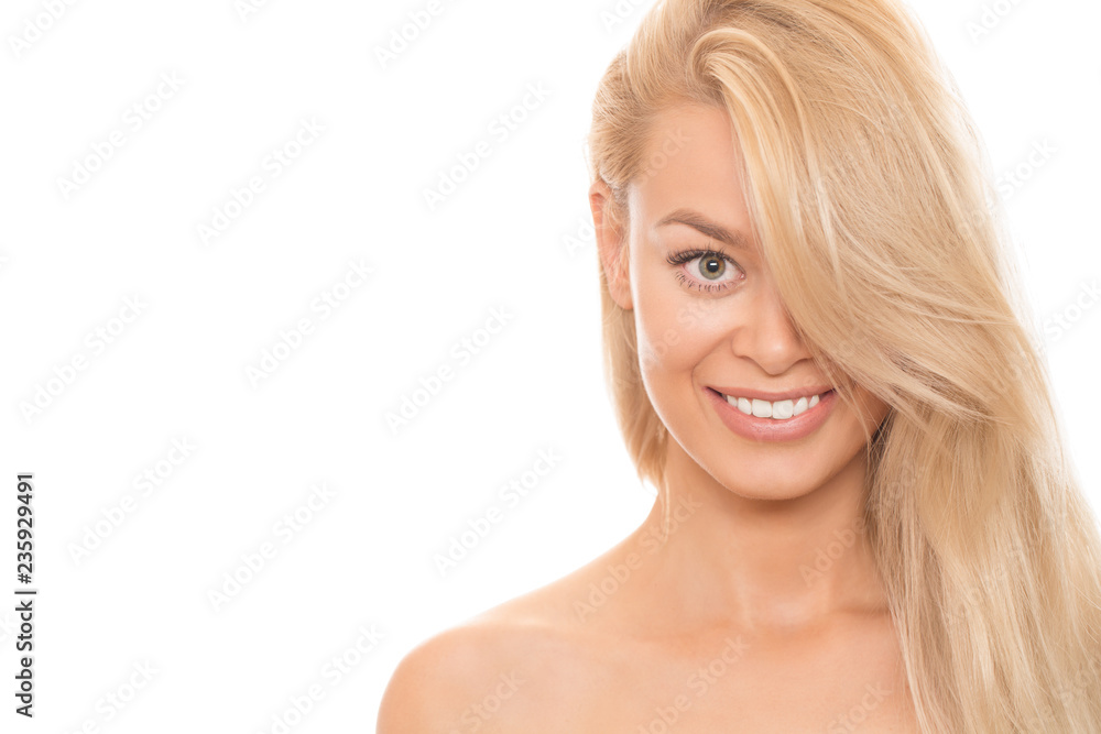 Happy young beautiful woman with long healthy strong hair covering half of her face smiling to the camera cheerfully isolated hairstyle blondie care positivity beauty cosmetology spa treatment Happy young beautiful woman with long healthy strong hair covering half of her face smiling to the camera cheerfully isolated hairstyle blondie care positivity beauty cosmetology spa treatment