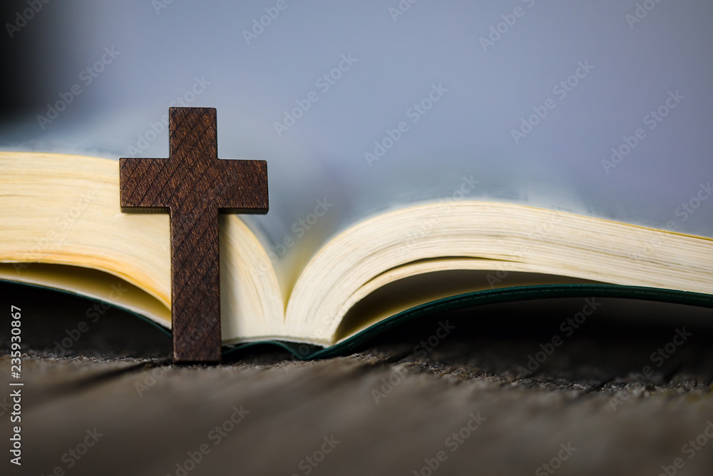 Cross on book on wooden table Cross on book on wooden table