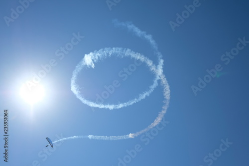 The trail of the plane in the sky in the form of a spiral, drawings in the sky, the smoke of the plane