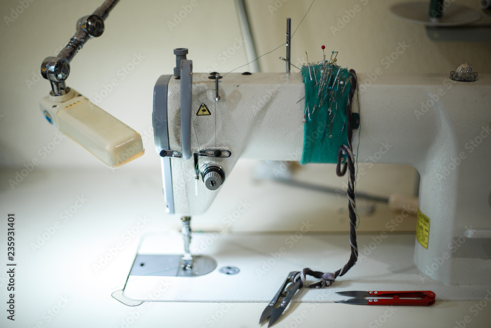 seamstress workplace. Sewing machine scissors threads and other tools. Tailoring industry