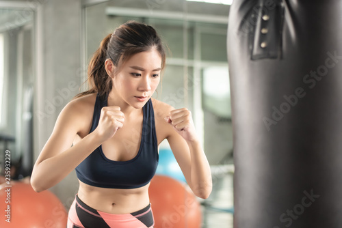 Attractive female boxer training with kick boxing at gym with blackgloves. © ic36006